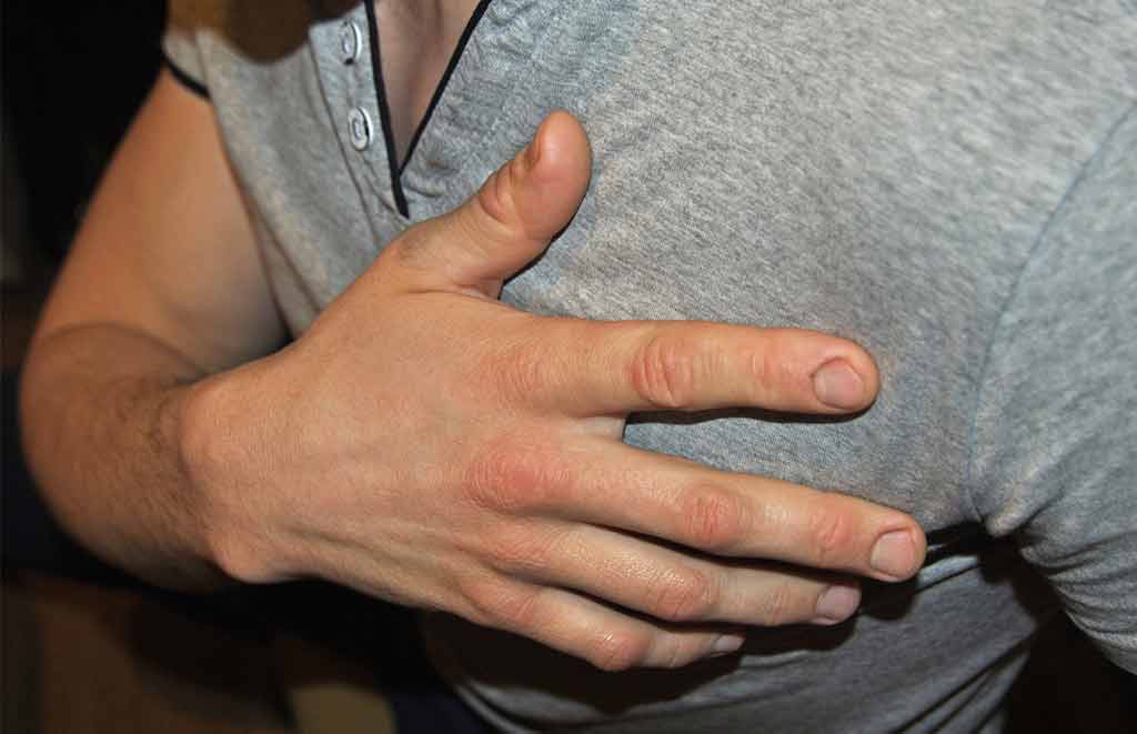 Man holding chest with heart attack